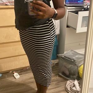A long and tight fitting black and white tripped skirt
